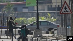 FILE - Police officers detain a protester at the Lekki toll gate in Lagos, Nigeria, Wednesday Oct. 21, 2020. Activists are now accusing authorities of trying to cover up the extent of the casualties at the gate.