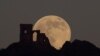 Bulan purnama &quot;Serigala&quot; (Wolf Moon) tampak di atas puri Mow Cop Folly, di Mow Cop, Inggris, 17 Januari 2022. (Foto: Reuters)