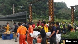 Rescuers carry a body on a stretcher at the site after a train derailed in a tunnel north of Hualien, Taiwan, April 2, 2021.