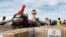 FILE —Workers unload humanitarian aid at Egypt's al-Arish Airport on November 22, 2023, ahead of being transported to the Rafah border area with the Gaza Strip.