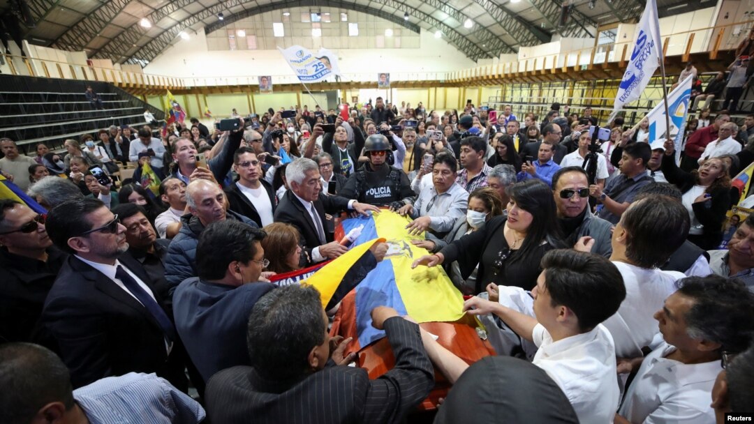 Familiares y amigos rodean el féretro de Fernando Villavicencio durante su sepelio en el Centro de Exposiciones de Quito, el 11 de agosto de 2023.
