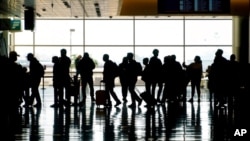 FILE - Travelers walk through the Salt Lake City International Airport in Salt Lake City, March 17, 2021. Mother's Day weekend meant bigger crowds at U.S. airports. 