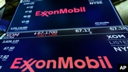 FILE - The logo for ExxonMobil appears above a trading post on the floor of the New York Stock Exchange, Oct. 8, 2019. 