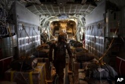 FILE—A members of the U.S. Air Force checks the containers with humanitarian aid as he flies toward Gaza Strip after departing from Jordan, March 14, 2024.