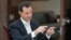 FILE - In this file photo released by the Syrian official news agency SANA, Syrian President Bashar Assad speaks during an interview with the Greek Kathimerini newspaper, in Damascus, May 10, 2018.
