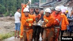 Petugas penyelamat mengangkut korban cedera akibat gempa di desa Gengdi, Sichuan, China hari Selasa (8/8). 