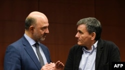 European Commissioner for Economic and Financial Affairs, Taxation and Customs Pierre Moscovici (L) talks with Greek Finance Minister Euclid Tsakalotos (R) prior to an Eurogroup meeting on Nov. 23, 2015 at EU Headquarters in Brussels. 