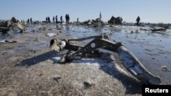 Petugas darurat di lokasi jatuhnya pesawat Boeing 737-800 Penerbangan FZ981 yang dioperasikan oleh FlyDubai, di bandara Rostov-On-Don, Rusia (20/3). (Reuters/Maxim Shemetov)