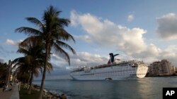 FILE - The Carnival Imagination cruise ship passes South Pointe Park in Miami Beach, Fla. as it leaves the Port of Miami.