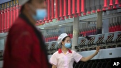 中國政府2021年4月組織外媒參觀新疆一個棉紡廠，試圖反擊國際社會有關新疆強迫勞動的指責。（美聯社）