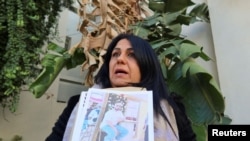 FILE - Ines Lafi, sister of Mohammed Lafi who she says was one of 40 people who went missing in January when their boat disappeared after setting off from a beach near the port of Sfax for the Italian island of Lampedusa, in Tunis, Tunisia February 6, 2024.