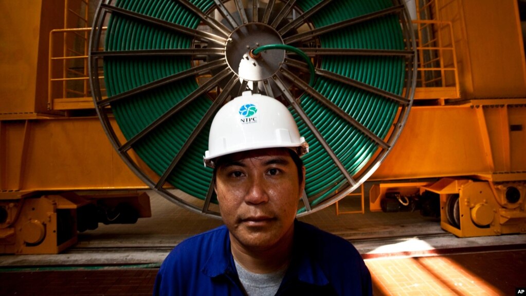 资料照：一名老挝工人在一个水利发电大坝里工作。(photo:VOA)