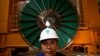 FILE - In this photo taken on Oct. 22, 2010, Laotian worker Phoumgeumh Chanthasone stands watch inside the power station of the Nam Theun 2 dam project near Mahaxaitai, Laos.