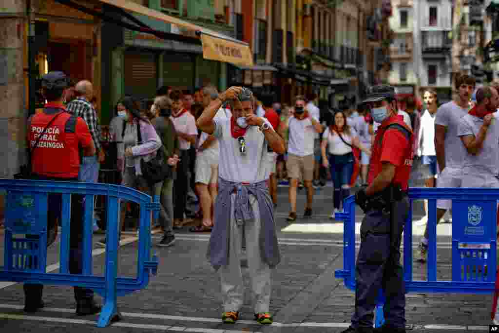 مردم با لباس‌های سفید و دستمال‌های قرمز در شهر پامپلونا اسپانیا برای فستیوال گاوبازی که در این روزها برگزار می‌شود، آماده می‌شوند. 