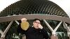 Howard, seorang warga Australia keturunan Tionghoa, yang wajahnya mirip Kim Jong Un, berpose dengan berpura-pura tidak tahan bau buah durian di Esplanade, Singapura.