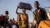 South Sudanese returnees who have fled from the war in Sudan carry their belongings while arriving at a Transit Centre for refugees in Renk, on February 14, 2024.More than 550,000 people have now fled from the war in Sudan to South Sudan since the conflic