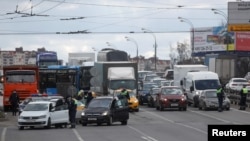 Traffic police officers stop cars and verify passengers' documents at a check point on the outskirts of Moscow, Russia April 15, 2020. 