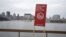 A sign stating "Don't touch the water" is seen near the St. Lawrence river as the city of Montreal is seen in the background, Nov. 11, 2015. Montreal, Canada's second-largest city, began dumping untreated sewage into the St. Lawrence River on Wednesday.