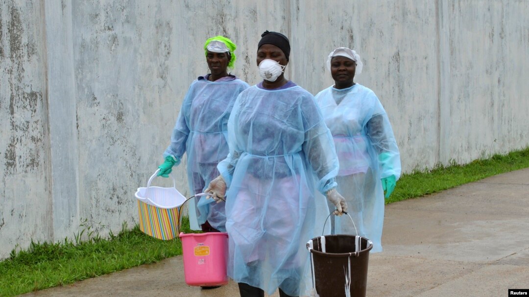 Nhân viên y tế xách các thùng nước khử trùng tại trung tâm điều trị Ebola ở Monrovia, Liberia, ngày 25/9/2014.