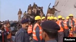 ບັນດານັກກູ້ໄພ ແລະ ປະຊາຊົນ ເຕົ້າໂຮມກັນຢູ່ສະຖານ
ທີ່ເກີດເຫດລົດໄຟຕົກລາງ ໃນເມືອງ Kanpur, ລັດ Uttar Pradesh, 20 ພະຈິກ, 2016.