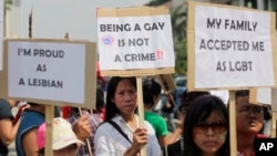 FILE - Indonesian gay activists hold posters during a protest demanding equality for lesbian, gay, bisexual and transgender people in Jakarta, May 21, 2011.