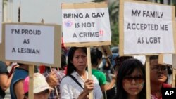 FILE - Indonesian gay activists hold posters during a protest demanding equality for LGBT (Lesbian, gay, bisexual and transgender) people in Jakarta, Indonesia, May 21, 2011.