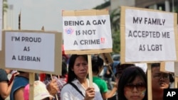 FILE - Indonesian gay activists hold posters during a protest demanding equality for LGBT people in Jakarta, Indonesia, May 21, 2011.