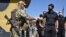 FILE - Ukraine's parliament speaker Dmytro Razumkov, right, greets a soldier at a checkpoint in Mayorsk, Donetsk region, Ukraine, July 29, 2020. Ukrainian and rebel forces in eastern Ukraine launched a comprehensive cease-fire two days earlier.