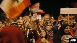 Lebanese protesters wave flags and shout slogans during an anti-government demonstration at al-Nour Square in the northern port city of Tripoli on November 2, 2019.