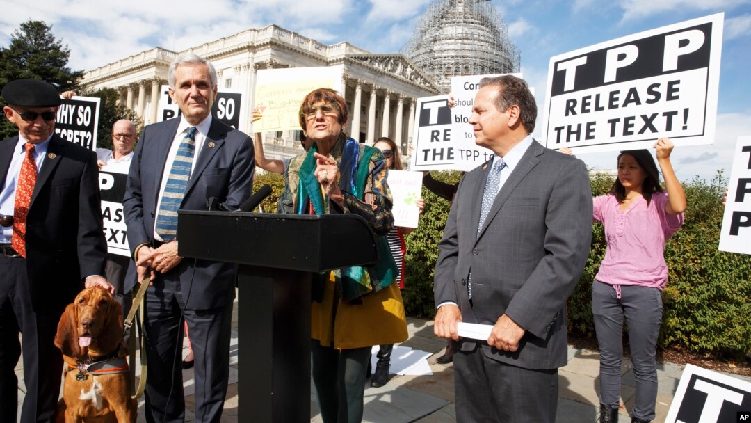 FILE - Rep. Rosa DeLauro, center, joined at left by Rep. Lloyd Doggett, a bloodhound named Roxy, Rep. David Cicilline (r) and other members of Congress, speaks at a news conference on Capitol Hill in Washington, Oct. 29, 2015, about the details of the TPP.