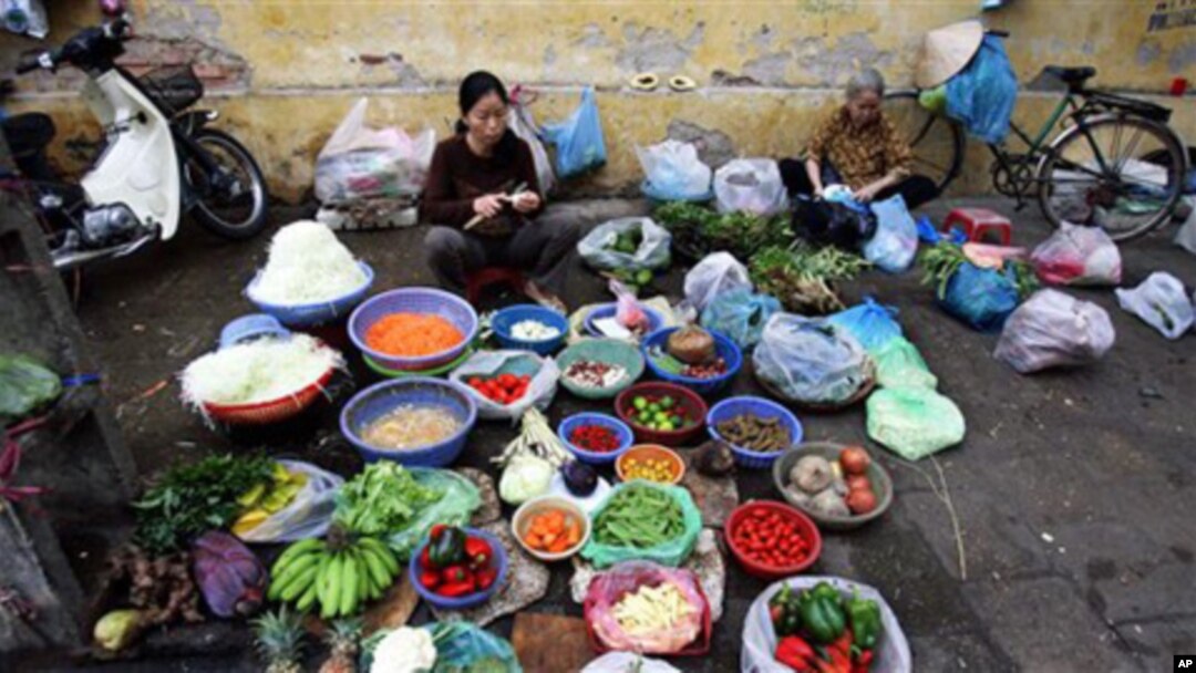 Vietnamese women gather to sell vegetables at a street market , in Hanoi. Vietnam's economy has braced market reform, but the recent boom may be facing some hard times (FILE).
