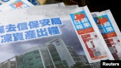 Copies of the Apple Daily newspaper are seen at a newspaper stall after it looked set to close for good by Saturday following police raids and the arrest of executives in Hong Kong, China June 22, 2021. REUTERS/Tyrone Siu