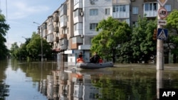 FILE - Ukrainian security forces transport local residents in a boat during an evacuation from a flooded area in Kherson on June 7, 2023, following damage sustained at Kakhovka hydroelectric power plant dam.