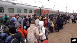 (FILE) Children deported from settlements bordering Ukraine board a train to relocate to Penza, in Belgorod, Russia.