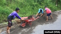 Anak-anak melewatkan waktu libur sekolah mereka dengan menambang pasir (Foto: VOA/Nurhadi)