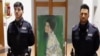 Polisi berdiri di dekat sebuah lukisan "Portrait of a Woman" karya pelukis Austria Gustav Klimt. Lukisan tersebut ditemukan setelah dicuri lebih dari 20 tahun. (Foto: AFP/Polizia di Stato/Kepolisian Italia)