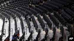 Workers clean the Wells Fargo Center after an NBA basketball game between the Philadelphia 76ers and the Detroit Pistons, Wednesday, March 11, 2020, in Philadelphia.