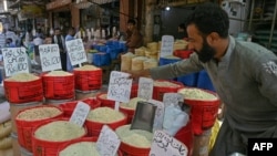 A shopkeeper arranges price tags his grocery shop in Karachi on Sept. 26, 2024. Pakistan said it will go through "transitional pain" after the International Monetary Fund agreed to a new relief package of $7 billion to bolster its faltering economy. 