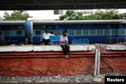 Siddharth Dhage, 10, waits for the train to arrive after filling his containers with water at Aurangabad railway station, India, July 17, 2019.