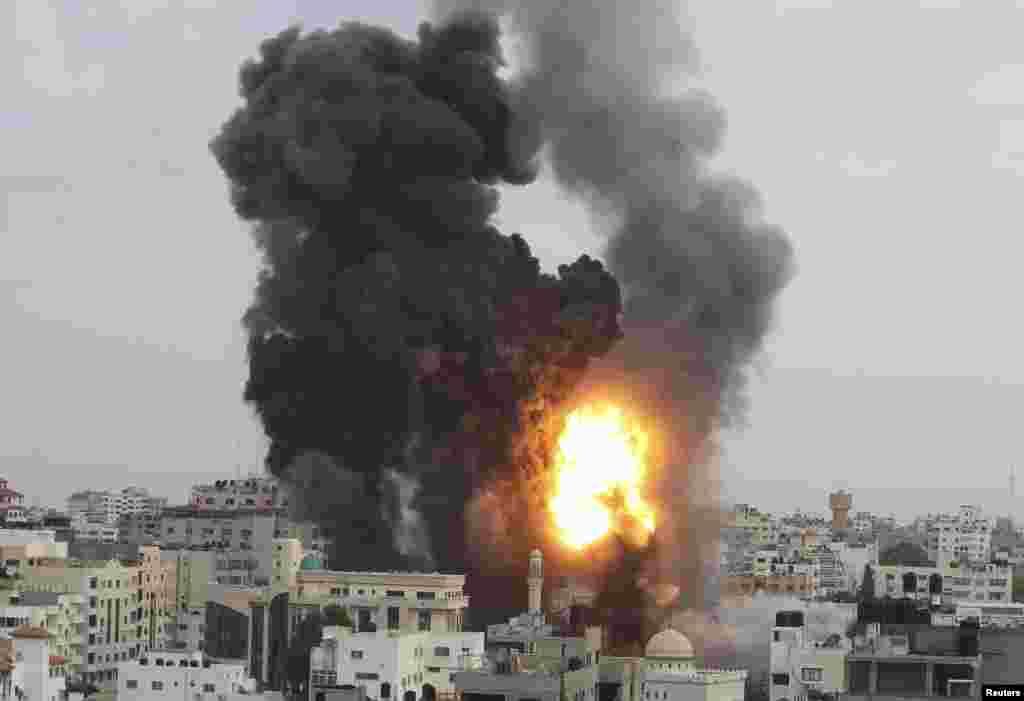 An explosion and smoke are seen after Israeli strikes in Gaza City November 17, 2012. Israeli aircraft pounded Hamas government buildings in Gaza on Saturday, including the building housing the prime minister's office, after Israel's Cabinet authorised th