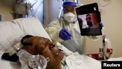 Florence Bolton, 86, a coronavirus disease (COVID-19) positive patient, lies in her intensive care bed as family members attempt to FaceTime her at Roseland Community Hospital on the South Side of Chicago, Illinois, Dec. 1, 2020. 