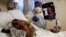 Florence Bolton, 86, a coronavirus disease (COVID-19) positive patient, lies in her intensive care bed as family members attempt to FaceTime her at Roseland Community Hospital on the South Side of Chicago, Illinois, Dec. 1, 2020. 