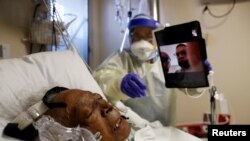 Florence Bolton, 86, a coronavirus disease (COVID-19) positive patient, lies in her intensive care bed as family members attempt to FaceTime her at Roseland Community Hospital on the South Side of Chicago, Illinois, Dec. 1, 2020. 