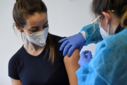 FILE - A German police staff member receives AstraZeneca's vaccine, in Munich, Germany, March 2, 2021.