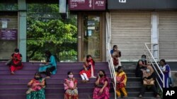 1일 인도 코치에서 마스크를 쓴 일용직 여성 노동자들이 일감을 기다리고 있다.