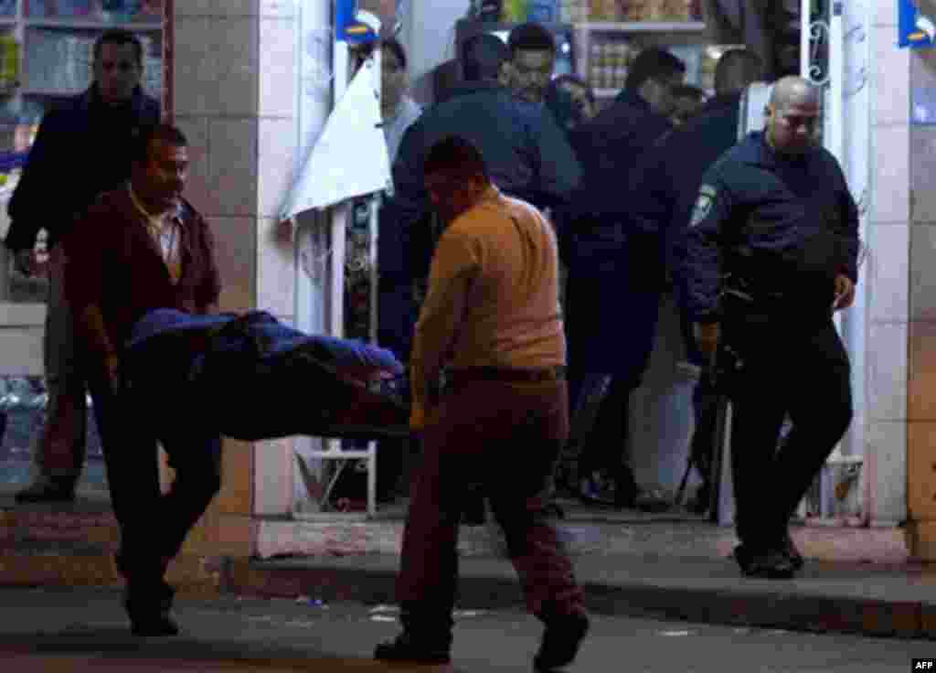 Forensics carry a corpse from a mini-market as city police investigate in the Zona Norte area of Tijuana, Mexico, late Tuesday Nov. 16, 2010. According to residents at the scene, a man was shot to death in the store. (AP Photo/Guillermo Arias)