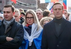 FILE - Russian opposition politicians Alexei Navalny, Lyubov Sobol and Ivan Zhdanov take part in a rally to mark the 5th anniversary of opposition politician Boris Nemtsov's murder, in Moscow, Feb. 29, 2020.