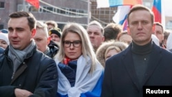 FILE - Russian opposition politicians Alexei Navalny, Lyubov Sobol and Ivan Zhdanov take part in a rally to mark the 5th anniversary of opposition politician Boris Nemtsov's murder, in Moscow, Feb. 29, 2020.