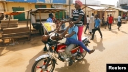 Des jeunes centrafricains se livre à des exercices acrobatiques sur une moto à proximité de la Mosquée Koudoukou où le pape François rencontre l'Imam Moussa Tidiani Naibi à Bangui, Centrafrique, 30 novembre, 2015. 