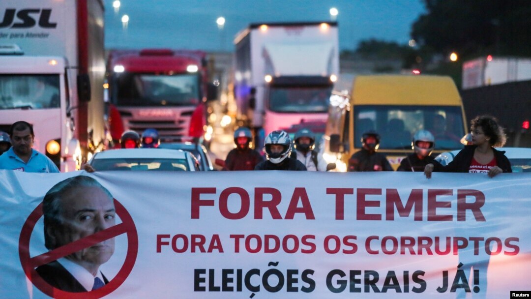 Protestors block the Presidente Dutra highway during a strike against Brazilian Social Welfare reform project from government, in Sao Jose dos Campos, Brazil, March 15, 2017. The banner reads: "Out, Temer. Out, all corrupt. Elections now." 